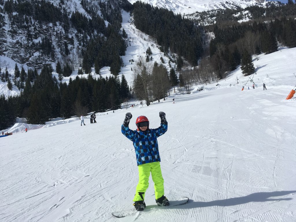 Minipixel les bras en l'air avec un snowboard aux pieds
