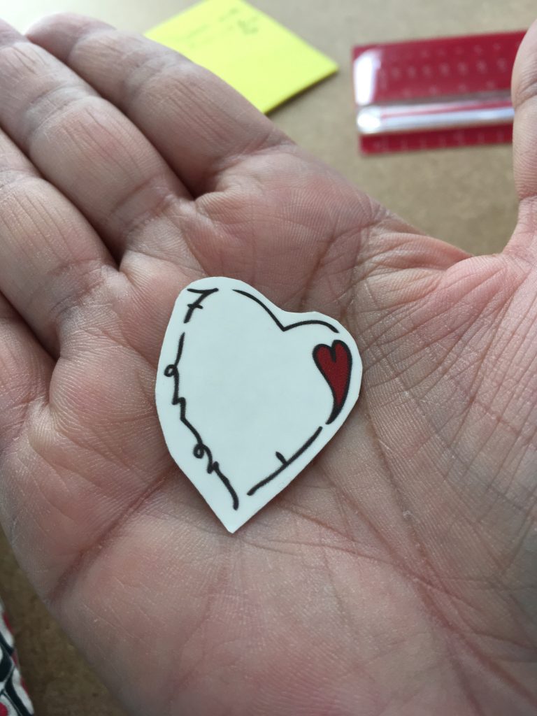 Tatouage temporaire de coeur prêt à être posé dans une main