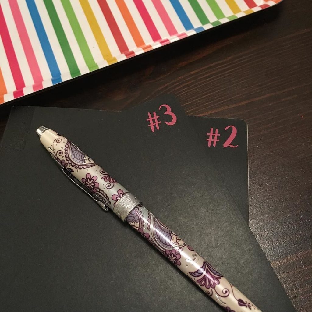 2 cahiers, un stylo plume et un plateau aux couleurs de l'arc en ciel