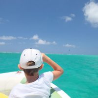 Minipixel avec une casquette sur une mer turquoise et ciel bleu.