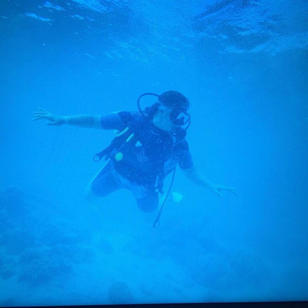 Sophie en combinaison de plongée dans l'eau les bras écartés