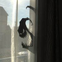 Sticker représentant un fantôme avec la gueule ouverte et un air sardonique collé sur une vitre de fenêtre