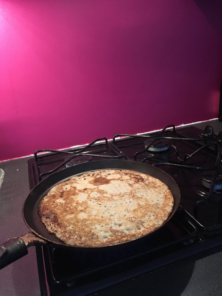 Photo de crêpière sur le gaz avec en fond un mur rose