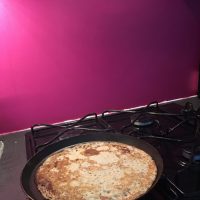 Photo de crêpière sur le gaz avec en fond un mur rose
