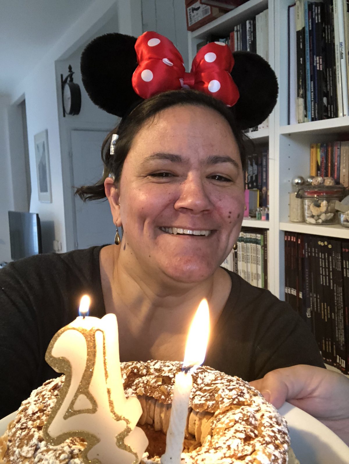 Sophie avec des oreilles de minnie et un gâteau portant des bougies dessus