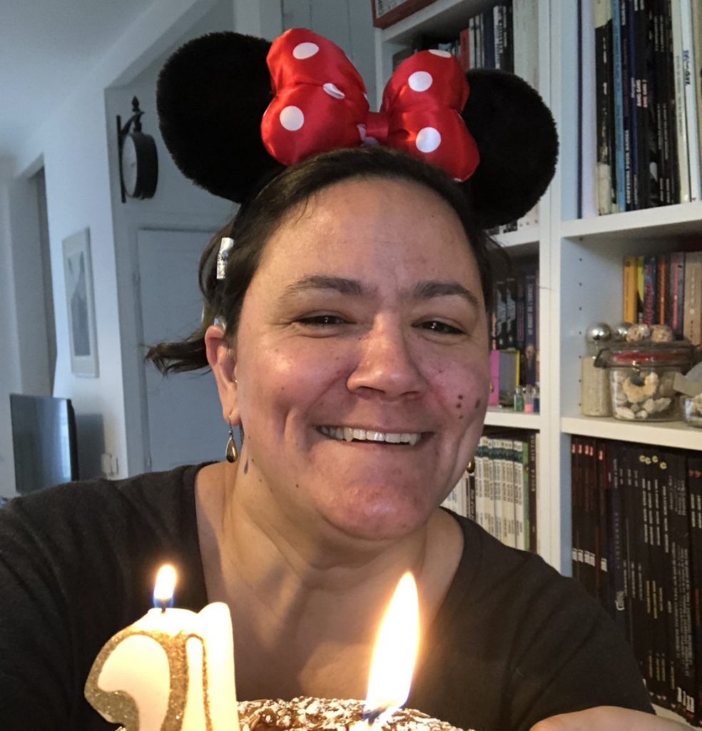 Sophie avec des oreilles de minnie et un gâteau portant des bougies dessus