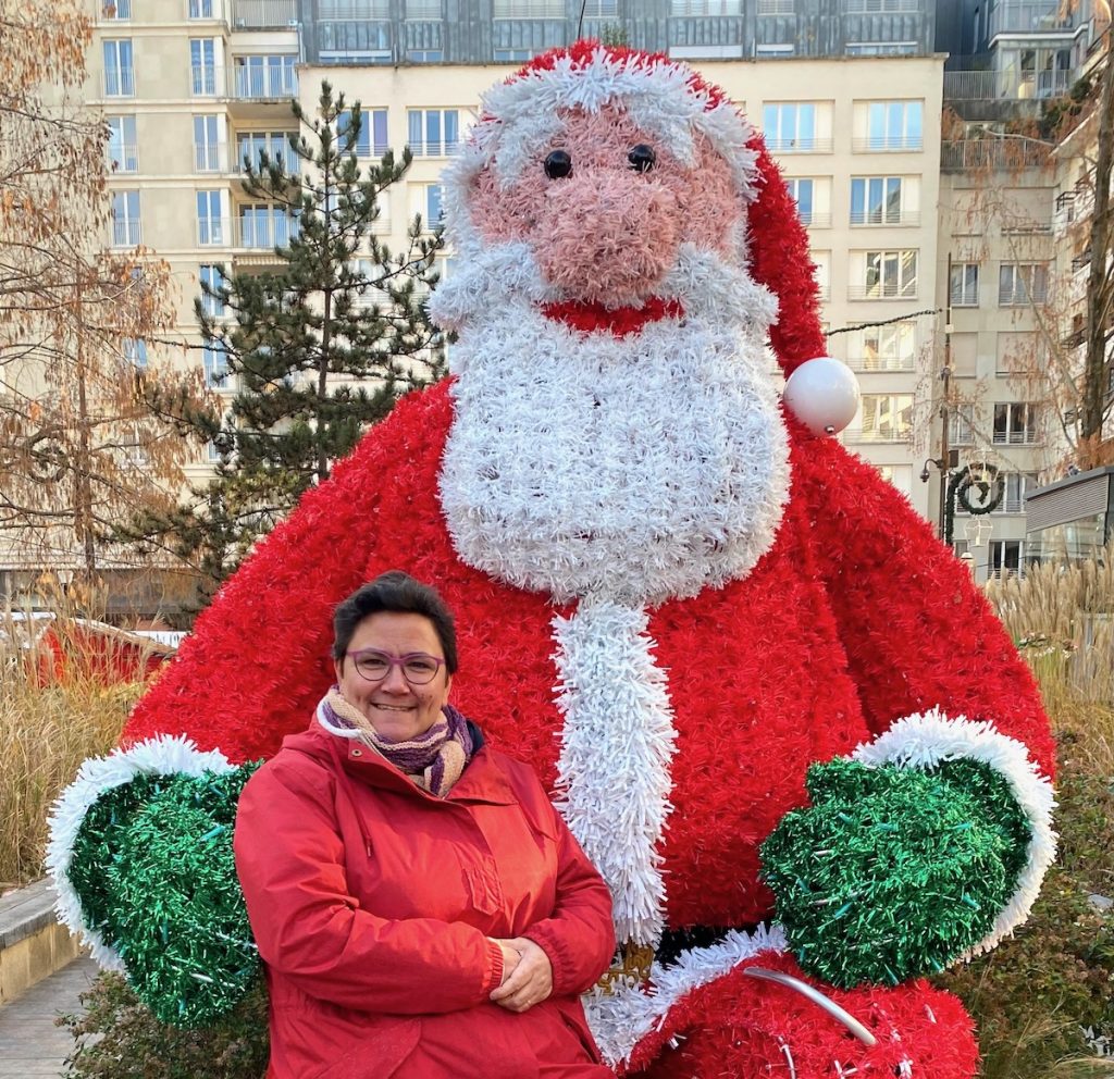 Sophie, assise sur les genoux d'un Père Noël qui fait 2 mètres 50 de haut.